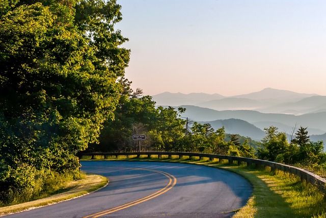 The Blue Ridge Parkway curves around a bend with mountain vista in distance