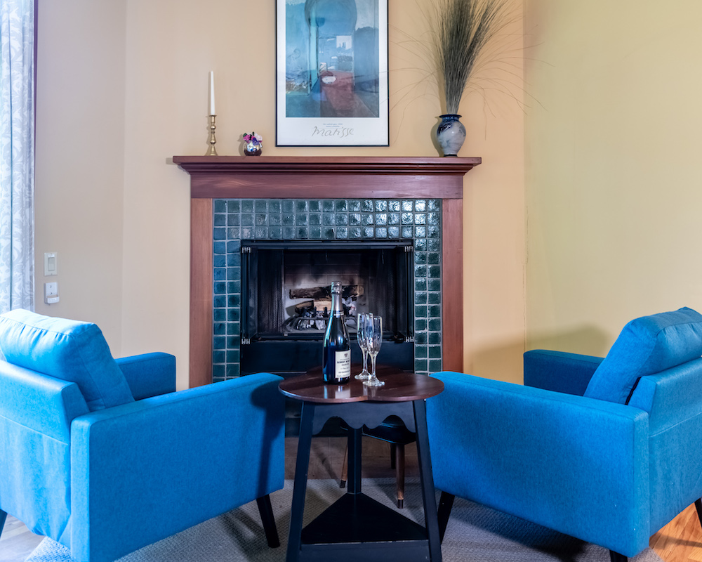 matching blue chairs in front of a fireplace