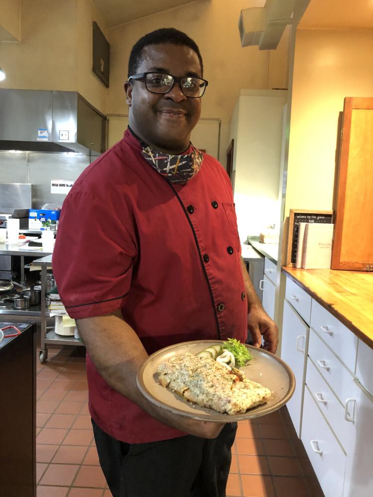 African American chef showing a plate of food
