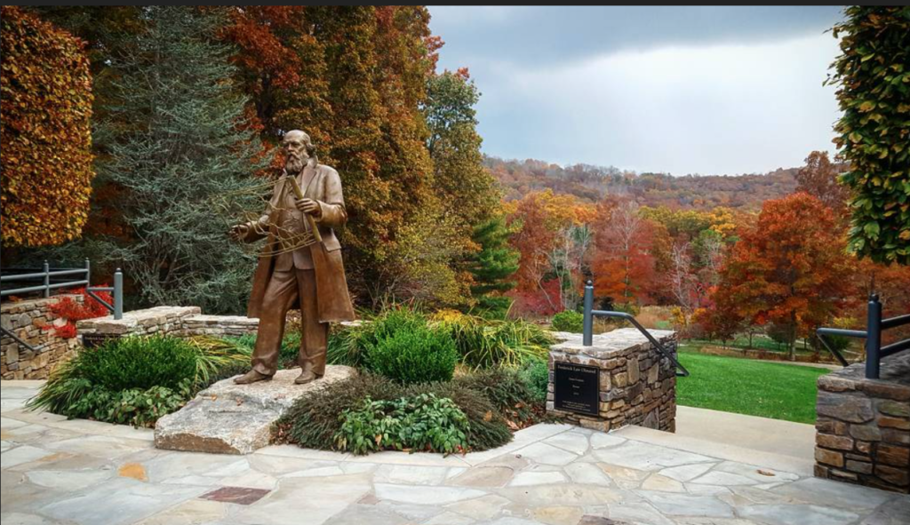 Sculptor of a man in a garden with fall colors